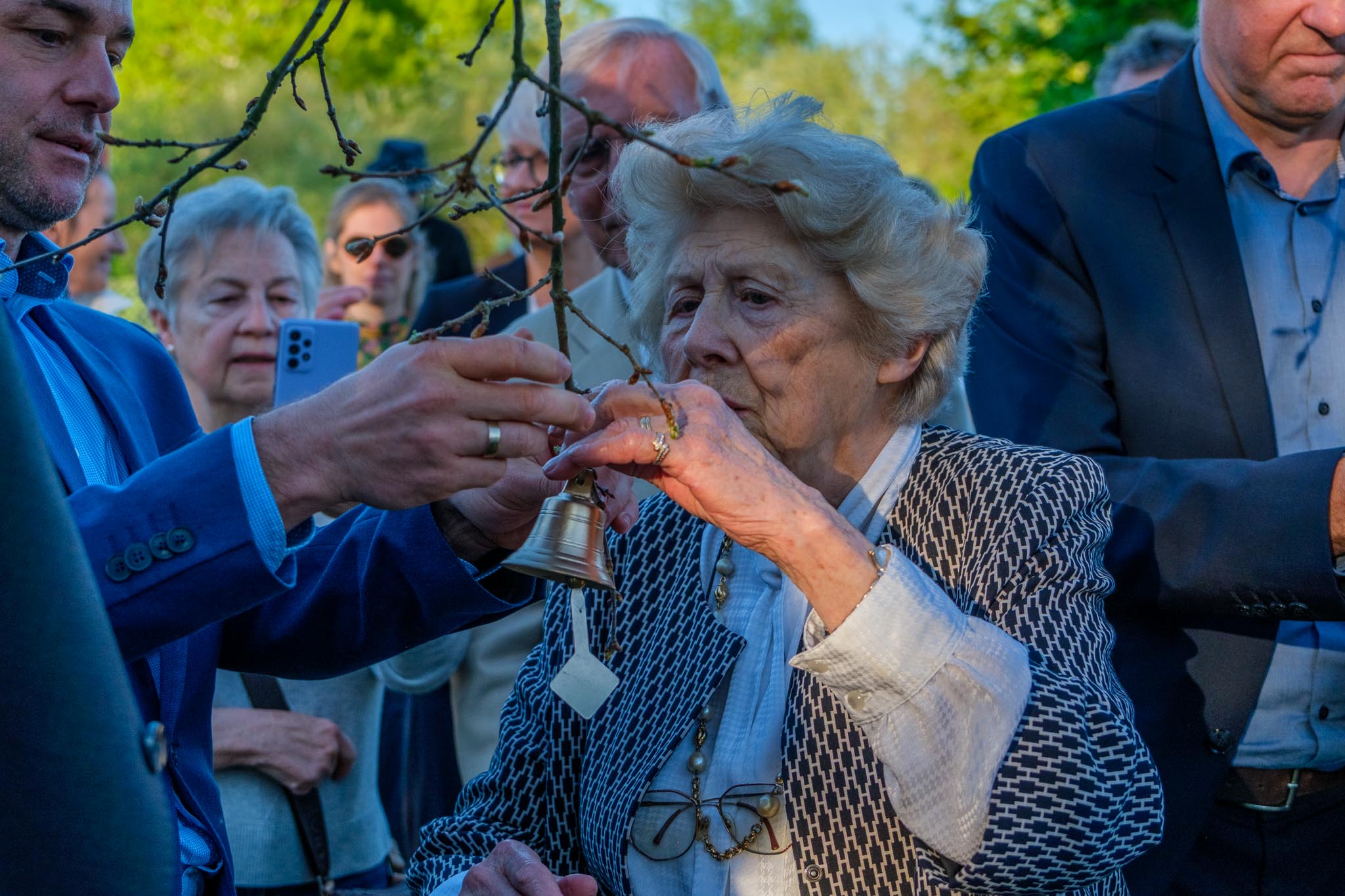 Lucette Malbecq-Cloizeau befestigt während der Gedenkgeier ein Glöckchen am Baum. Foto: Frank Schildener
